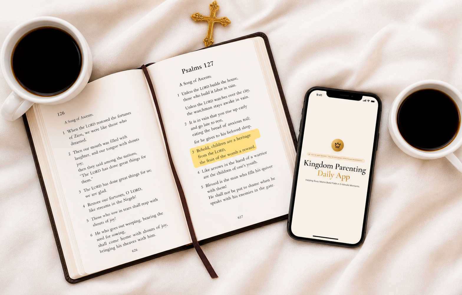 Open Bible, gold cross, coffee, and a phone showing a daily verse